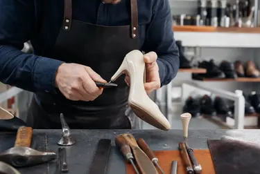 Profissional consertando o zíper de uma bota em Itapecerica da Serra.